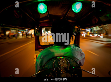 Tuk Tuk Driver Zips his way through Bangkok Stock Photo