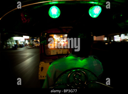 Tuk Tuk Driver Zips his way through Bangkok Stock Photo