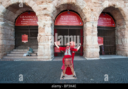 Street performer dressed as a roman centurion poses in front of  Arena ticket office, Verona, Italy Stock Photo