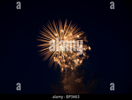 multi coloured fireworks erupting in the night sky over water Stock Photo