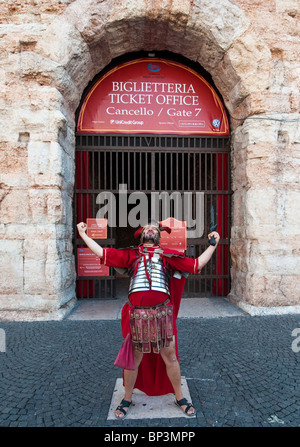 Street performer dressed as a roman centurion poses in front of  Arena ticket office, Verona, Italy Stock Photo