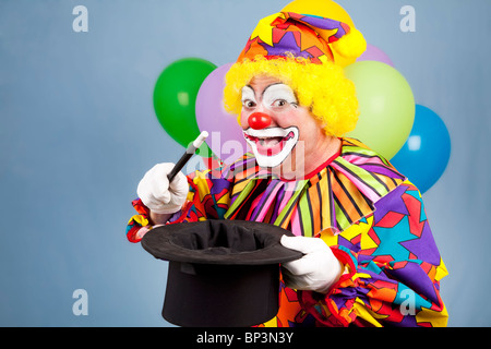 Happy birthday clown doing magic tricks with a top hat and wand.  Stock Photo