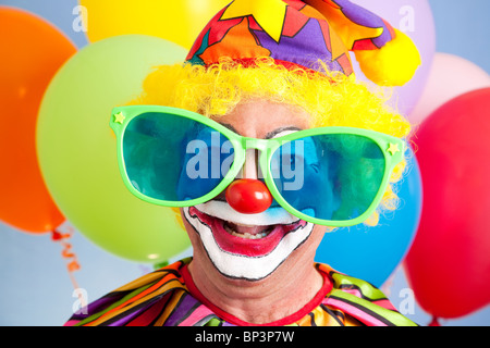 Portrait of silly clown in oversized sunglasses. Stock Photo