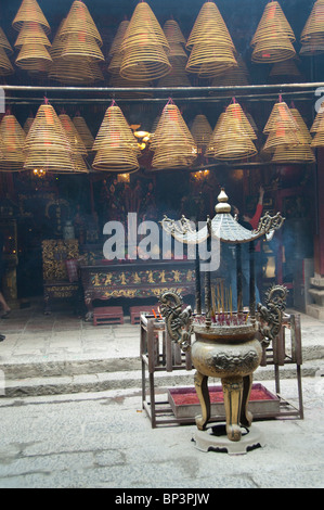 China, Hong Kong, New Territories, Tai Po area. Inside famous Man Mo Temple, hanging coils of burning incense used as offering. Stock Photo