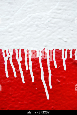 Wall with white dripping paint running over red background. Abstract texture. Stock Photo