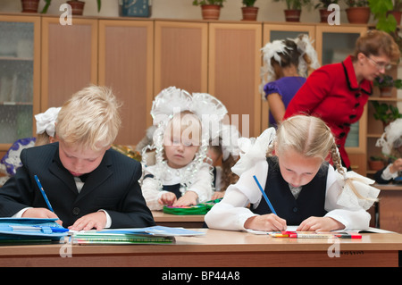 Russian boys and girls Caucasians students are sitting on the lesson in classroom in school at first September. Stock Photo