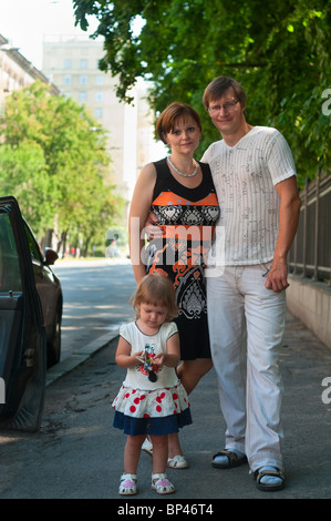 Happy parents near a new car and child here Stock Photo