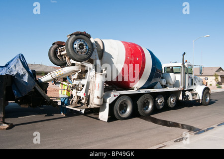 A concrete transfer truck feeds a concrete pumper in a residential construction site. Stock Photo