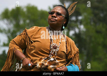 A Native American woman in full traditional regalia parades in the dance circle at the 8th Annual Red Wing PowWow in Virginia Be Stock Photo