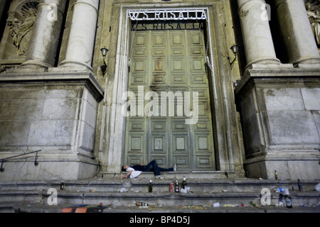 Young man falling asleep on a church steps after the celebration for Santa Rosalia fest Palermo, Sicily, Italy. Stock Photo