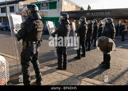 Police riot squad line up across a road in preparation for civil disturbance Stock Photo