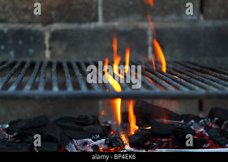 Bar b cue barbecue fire BBQ coal fire iron grill brick wall Stock Photo