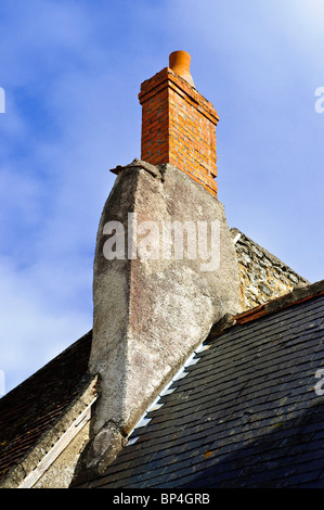 Newer tall chimney built onto old stone stack - France. Stock Photo