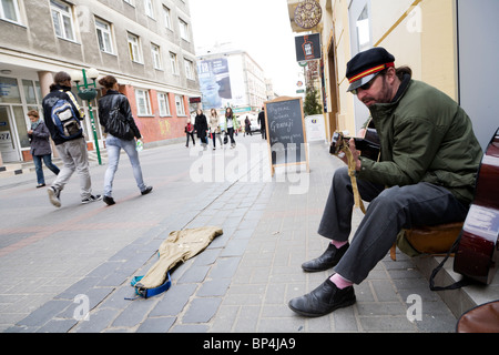 Busker playing guitar on Chmielna street, Warsaw Poland. Stock Photo