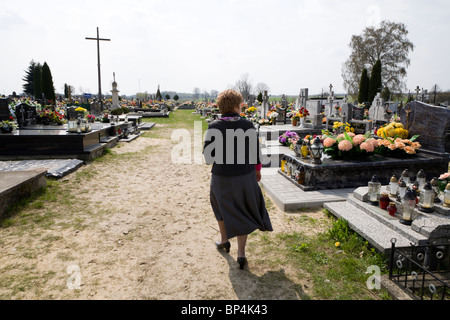 Woman looking for the grave of a loved-one in a cemetery.  Gmina Przylek, Zwolen county, Poland. Stock Photo