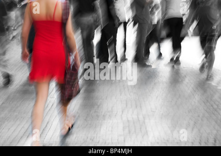 Busy big city street. Woman in red among black and white Stock Photo