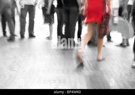 Busy big city street. Woman in red among black and white Stock Photo