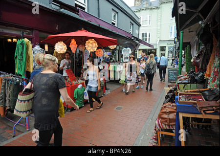 Shoppers browsing the stalls and shop windows in Kensington Gardens part of the North Laine area of Brighton UK Stock Photo