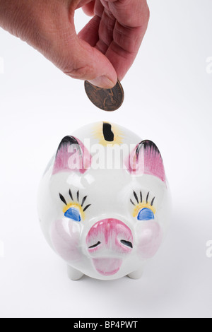 Saving money. Hand putting money into piggy bank. New Indian currency ...