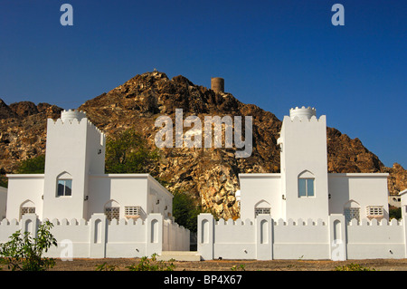New family homes beneath an old fortress in the periphery of Muscat, Sultanate of Oman Stock Photo