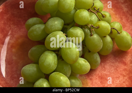 Green Grapes in a light red plate Stock Photo