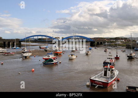 Boats moored in the estuary of the River Clwyd with the blue Foryd road bridge in the background, Rhyl Stock Photo