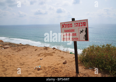 Israel, Sharon region, Netanya, Danger landslide warning sign on the cliff of the promenade Stock Photo