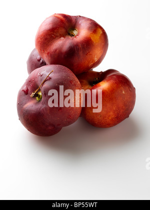 A pile of flat peento nectarines on a white background Stock Photo