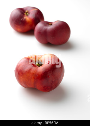 A pile of flat peento nectarines on a white background Stock Photo - Alamy