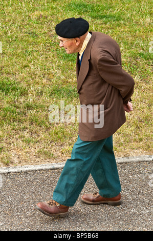 Overhead view of old hunched man walking slowly along pavement - France. Stock Photo