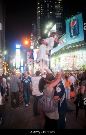 Visitors to Times Square in New York kiss and view the 26 foot tall 'Unconditional Surrender' sculpture by Seward Johnson Stock Photo