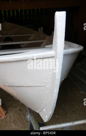 Traditionally built Norwegian wooden rowing boat, painted white.  Inside a boatshed at the marine museum in Norheimsund, Norway Stock Photo