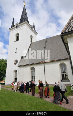 People with costumes going to church at Midsummer celebration in Svaerdsjoe, Sweden Stock Photo