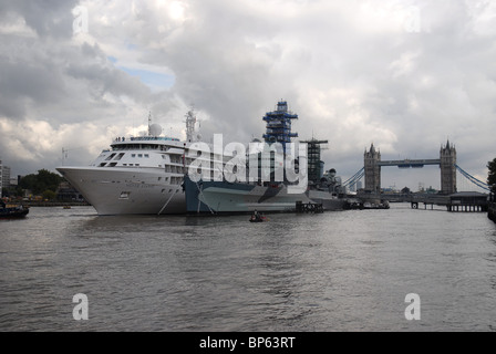 Cruise liner Silver Cloud moored next to HMS Belfast on the River Thames with Tower Bridge in the background Stock Photo
