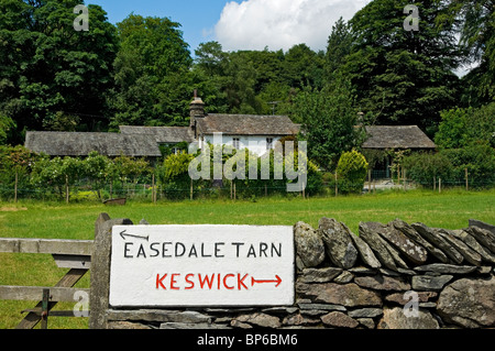 Sign on wall showing direction of Keswick and Easedale Tarn in summer Grasmere Lake District National Park Cumbria England UK United Kingdom Britain Stock Photo