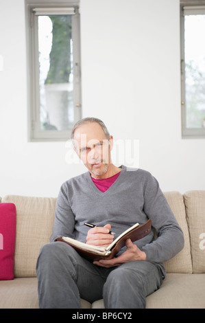 Portrait of a man writing in a personal organizer Stock Photo