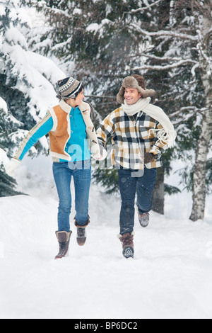 Young couple running in snow Stock Photo
