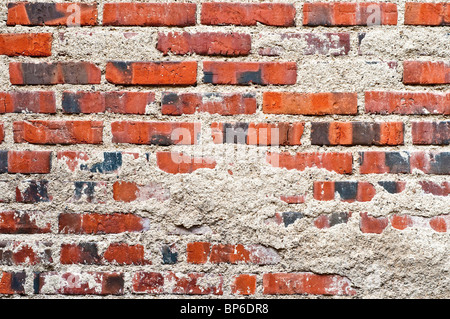 Old brick wall with rendering falling off - France. Stock Photo
