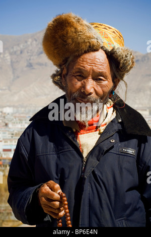 Portrait of a traditionally dressed man on the Potala Palace, in Lhasa, Tibet Stock Photo