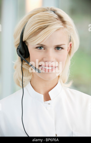 Portrait of a smiling female customer representative with phone headset ...