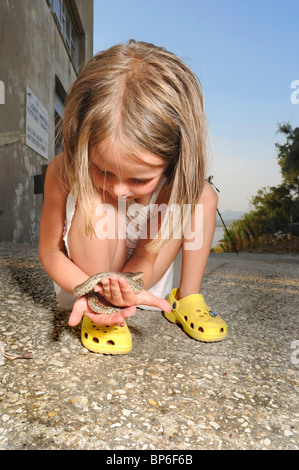 Javelin sand boa (Eryx jaculus), small girl with a boa on her hand, Greece Stock Photo