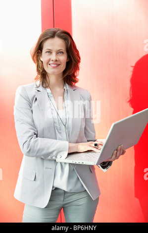 Portrait of a woman using a laptop and smiling Stock Photo