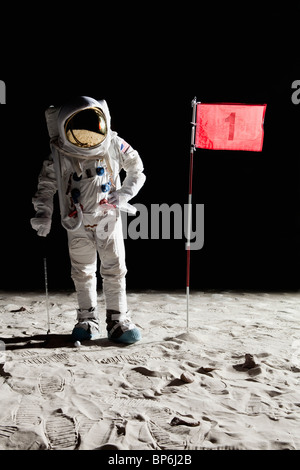 An astronaut on the moon standing next to number 1 hole flag Stock Photo