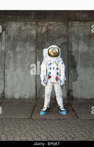 An astronaut standing on a sidewalk in a city Stock Photo