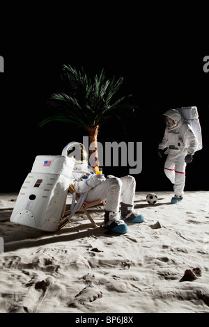 Two astronauts on the moon enjoying some leisure time Stock Photo