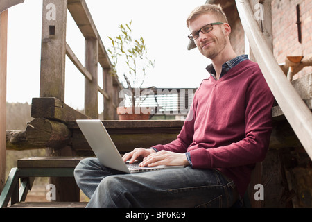 A man with a laptop sitting on a staircase Stock Photo