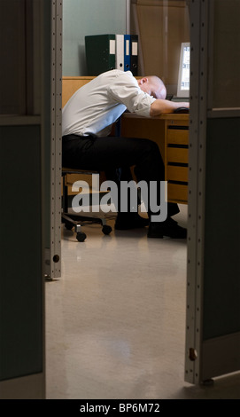 Late night office worker fallen asleep while working overtime. Stock Photo