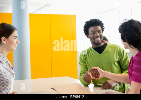 Businessmen shaking hands in an office Stock Photo