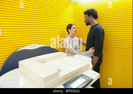 Business couple romancing near a photocopy machine Stock Photo