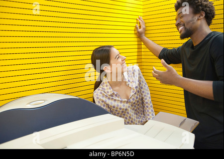 Business executives standing near photocopy machine and smiling Stock Photo